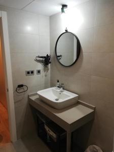 uma casa de banho com um lavatório e um espelho em Apartamento Servet, parking gratuito, a 5 minutos de Sevilla em Bormujos