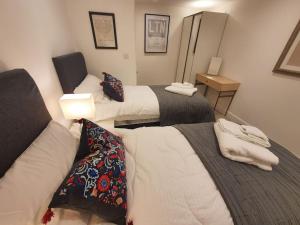 a hotel room with two beds and a mirror at Luton Town Centre Executive Apartment in Luton