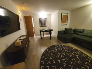a living room with a couch and a table at Luton Town Centre Executive Apartment in Luton