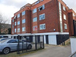 a brick building with a car parked in front of it at Luton Town Centre Executive Apartment in Luton