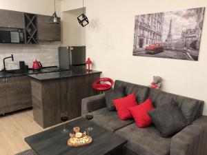 uma sala de estar com um sofá e uma mesa com almofadas vermelhas em Karen's Dom & Terrace em Yerevan