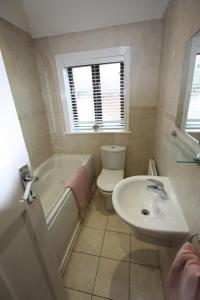 a bathroom with a sink and a toilet and a bath tub at Lymm Cottage in Lymm +14 photos