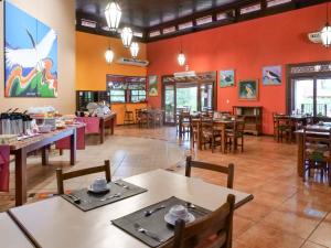 a restaurant with wooden tables and chairs and red walls at Hotel Pousada Águas de Bonito in Bonito