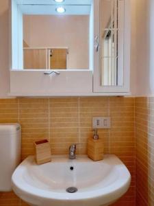 y baño con lavabo con espejo y aseo. en Sant'Oliva28, en Palermo
