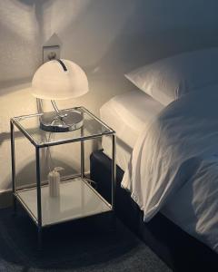 a nightstand with a lamp on it next to a bed at Modern K-style House in Seoul