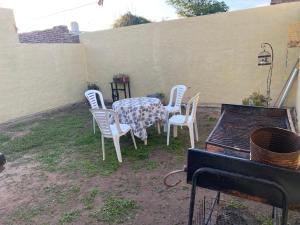 a table and chairs with a table and a grill at Departamentos Temporales con Wifi, Tv y Aire in Oliva