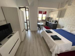 a bedroom with a bed and a tv and a kitchen at No. 110 / Downtown in Iaşi
