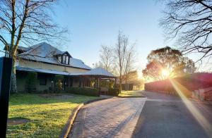 a house with the sun shining down a brick road at Briars Country Lodge in Bowral