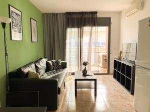 een woonkamer met een bank en een tafel bij Apartamentos OlaMar in Lloret de Mar