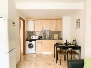 a kitchen with a table and a dining room at Apartamentos OlaMar in Lloret de Mar