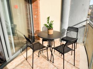 a table and chairs on a balcony with a plant at Apartamentos OlaMar in Lloret de Mar