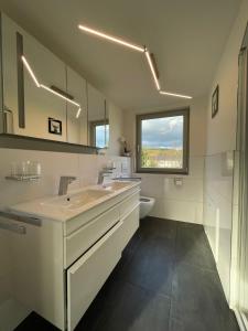 a bathroom with a sink and a toilet and a window at Exklusive Wohnung mit Ahrblick 1 und Dachterrasse in Bad Neuenahr-Ahrweiler