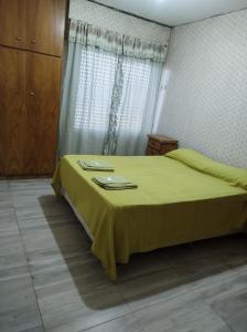 ein Schlafzimmer mit einem Bett mit einer gelben Decke darauf in der Unterkunft Renovado dpto Los Nietos in Villa María