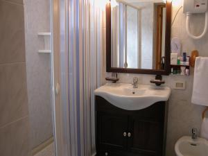 a bathroom with a sink and a mirror and a shower at Hotel Canusium in Canosa di Puglia