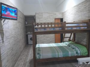 a room with two bunk beds and a tv at Monoambientes in Villa Alsina