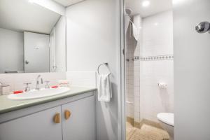 a white bathroom with a sink and a toilet at Nightcap at Hotel Victor in Victor Harbor