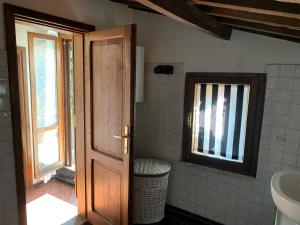 baño con puerta, lavabo y ventana en Porta Conca Apartments, en Rieti