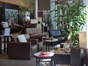 ein Wohnzimmer mit Sofas, Tischen und Pflanzen in der Unterkunft Hotel JAL City Haneda Tokyo in Tokio