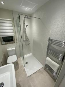 La salle de bains blanche est pourvue d'une douche et de toilettes. dans l'établissement Wharfedale Lodge- Bungalow-3 Bed, 2 bath, Amazing!, à Thornton