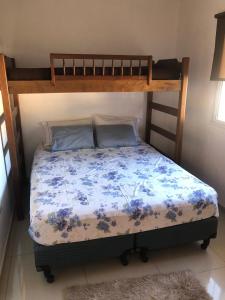 a bedroom with a bunk bed with a blue floral bedspread at Quincho Roca Plottier in Plottier +24 photos