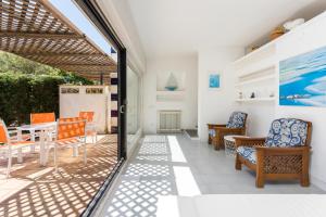 un patio con tavolo e sedie arancioni e blu di Luxury villa in front of the sea ROSITA a Calella de Palafrugell