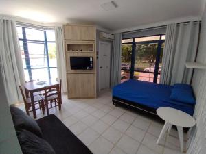1 dormitorio con 1 cama y sala de estar en Loft encantador a 40 metros do mar., en Florianópolis