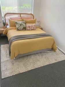 uma cama com almofadas em cima de um tapete em Stay Peachy - Kiama em Kiama