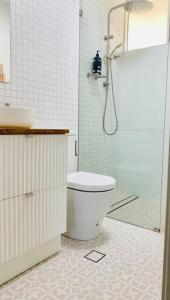 uma casa de banho com um WC, um chuveiro e um lavatório. em Stay Peachy - Kiama em Kiama