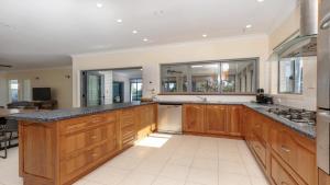 a large kitchen with wooden cabinets and a counter top at Newport Retreat in Yamba