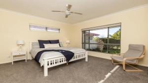 a bedroom with a bed and a window and a chair at Newport Retreat in Yamba +10 photos