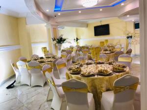 a banquet hall with tables and chairs and a television at Marriot Metropolitan Hotel in Douala