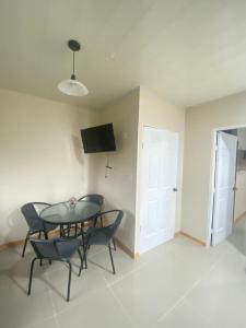 a dining room with a table and chairs and a television at Agutí Apartment in Manuel Antonio