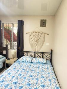 a bedroom with a bed with a blue and white comforter at Agutí Apartment in Manuel Antonio