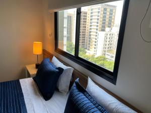 1 dormitorio con cama y ventana grande en Flat savassi super luxo, en Belo Horizonte