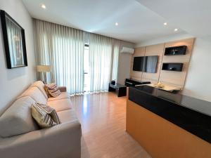 - un salon avec un canapé et une télévision dans l'établissement Flat savassi super luxo, à Belo Horizonte