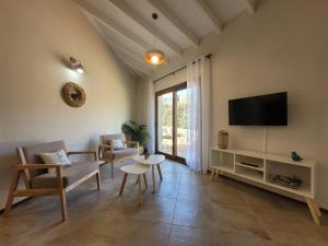 a living room with a tv and a couch and chairs at Aires del Sur in Dina Huapi