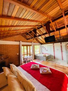 a bedroom with a large red bed in a room at Pousada Caminho da Mata in São Bento do Sapucaí