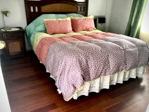 Una cama con almohadas y una manta. en Cabañas Esmeralda con Desayuno, en Punta Arenas