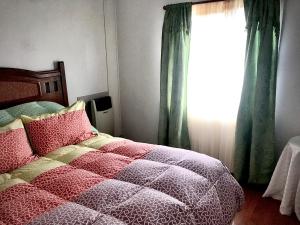 a bedroom with a bed and a window at Cabañas Esmeralda con Desayuno in Punta Arenas
