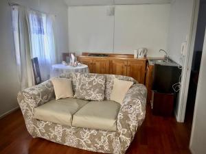 蓬塔阿雷納斯的住宿－Cabañas Esmeralda con Desayuno，客厅配有沙发和桌子