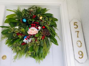 une couronne de christmas sur une porte avec un elf dessus dans l'établissement Serenity, à Burnaby