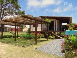 a small house with a wooden pergola at Un Sueño in Punta Del Diablo
