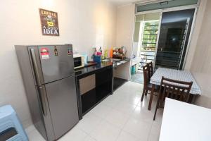a kitchen with a stainless steel refrigerator and a table at Cyberjaya Cyberia landed house BBQ By EC in Cyberjaya