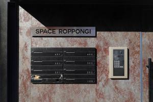 ein Schild, das das Dach neben einer Fernbedienung liest in der Unterkunft Space Roppongi in Tokio
