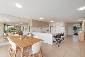 a kitchen and dining room with a table and chairs at 2 bedrooms apartment on the beach and with air conditioning and pool in Buddina +9 photos