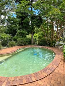 una pequeña piscina con una pasarela de ladrillo alrededor en Applegum Inn, en Toowoomba