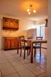 a kitchen with a table and chairs and a refrigerator at Departamento con Amplia Terraza en Excelente Zona in Ciudad Juárez