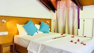 een slaapkamer met een bed met bloemen erop bij Masfalhi View Inn in Felidhoo