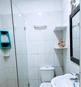 Baño blanco con aseo y lavamanos en House Marfito Airport, en Cartagena de Indias