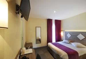 een hotelkamer met een bed en een televisie bij Comfort Hotel Saintes in Saintes
